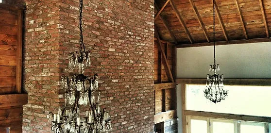 Vintage exposed electrical installation with chandeliers and brick.